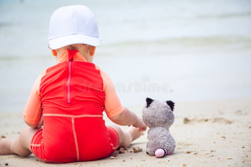Piccoli amici Bambino che gioca con l'animale del giocattolo sulla spiaggia con il mare sullo spazio della copia e del fondo fotografia stock Piccoli amici Bambino che gioca con l'animale del giocattolo sulla spiaggia con il mare sullo spazio della copia e del fondo fotografia stock