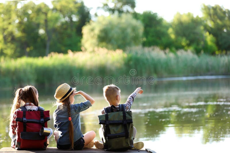 Piccoli bambini che si siedono sul pilastro di legno fotografie stock libere da diritti Piccoli bambini che si siedono sul pilastro di legno fotografie stock libere da diritti