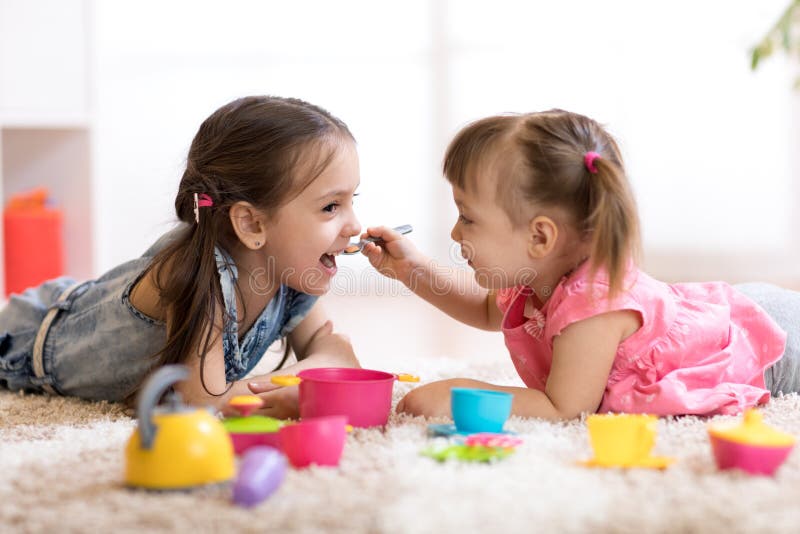 Piccoli bambini svegli che giocano con l'articolo da cucina mentre trovandosi sul pavimento a casa fotografia stock libera da diritti Piccoli bambini svegli che giocano con l'articolo da cucina mentre trovandosi sul pavimento a casa fotografia stock libera da diritti