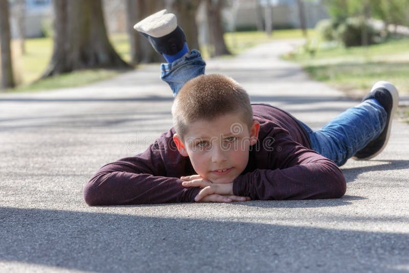 Piccolo bambino sveglio, ragazzo biondo del bambino che gioca all'aperto menzogne alla via immagini stock Piccolo bambino sveglio, ragazzo biondo del bambino che gioca all'aperto menzogne alla via immagini stock