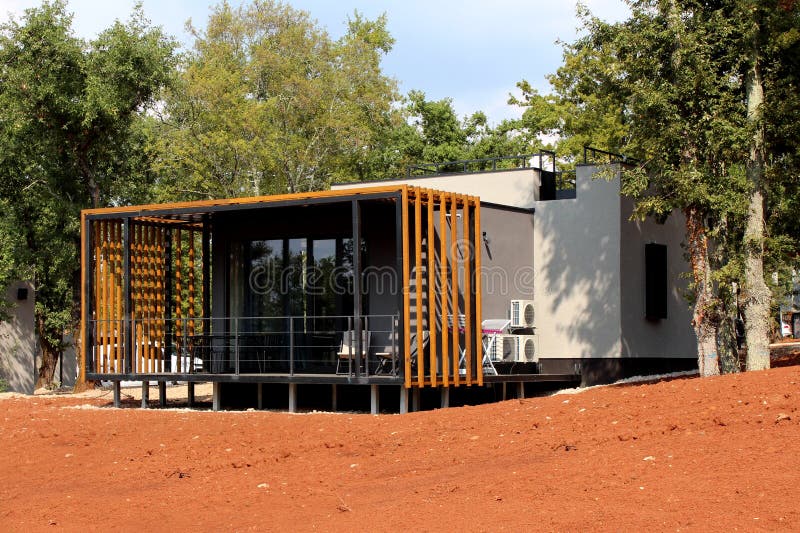 Piccolo bungalow moderno della località di soggiorno del mare di festa della famiglia con grande superficie di vetro ed il portic