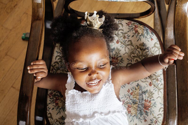Piccolo gioco afroamericano dolce sveglio della ragazza soddisfatto dei giocattoli a casa, concetto dei bambini di stile di vita immagine stock libera da diritti Piccolo gioco afroamericano dolce sveglio della ragazza soddisfatto dei giocattoli a casa, concetto dei bambini di stile di vita immagine stock libera da diritti
