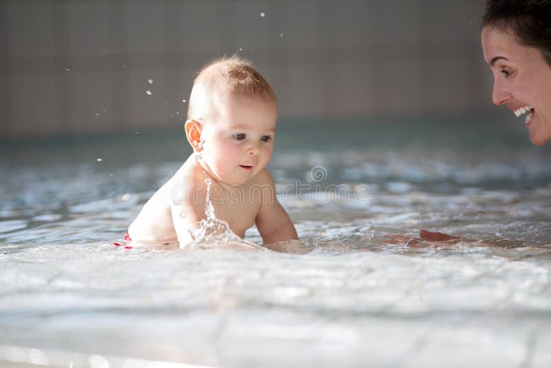 Piccolo neonato sveglio, nuotante felicemente in un'acqua bassa dello stagno fotografia stock libera da diritti Piccolo neonato sveglio, nuotante felicemente in un'acqua bassa dello stagno fotografia stock libera da diritti