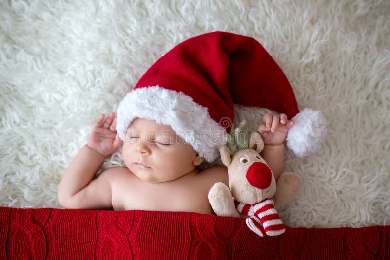 Piccolo ragazzo di neonato addormentato, cappello d'uso di Santa fotografia stock Piccolo ragazzo di neonato addormentato, cappello d'uso di Santa fotografia stock