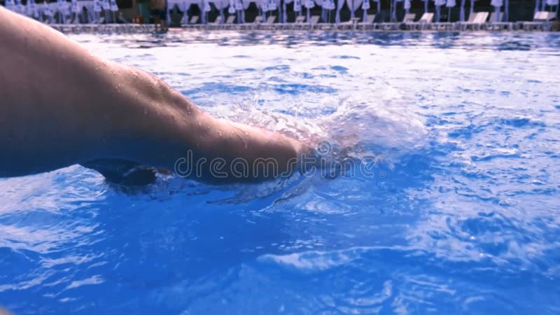 Picioare femele la piscina. picioarele femele tăbăcite jucându-se în apă albastră ripplantă în piscină stock video footage