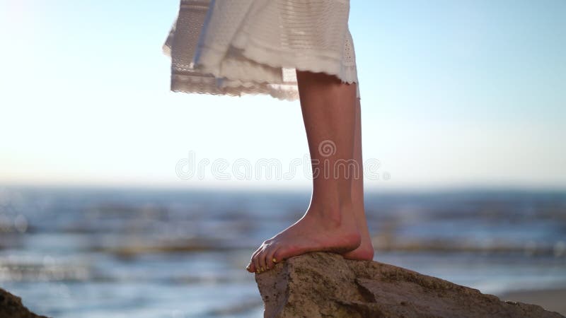Picioare femele în picioare pe o piatră pe bech. stock footage