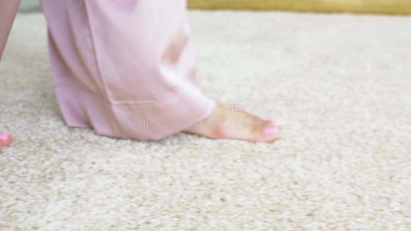 Picioarele goale de sex feminin plimbare pe covor de grămadă interior bej. stock footage