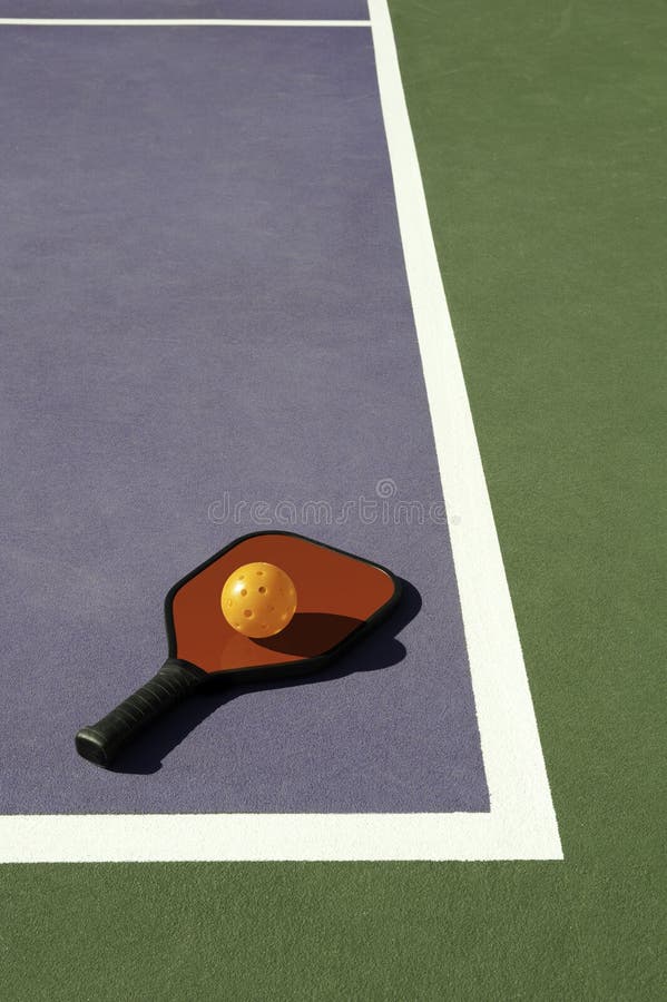 Pickleball and Red Paddle Laying on Edge of Court