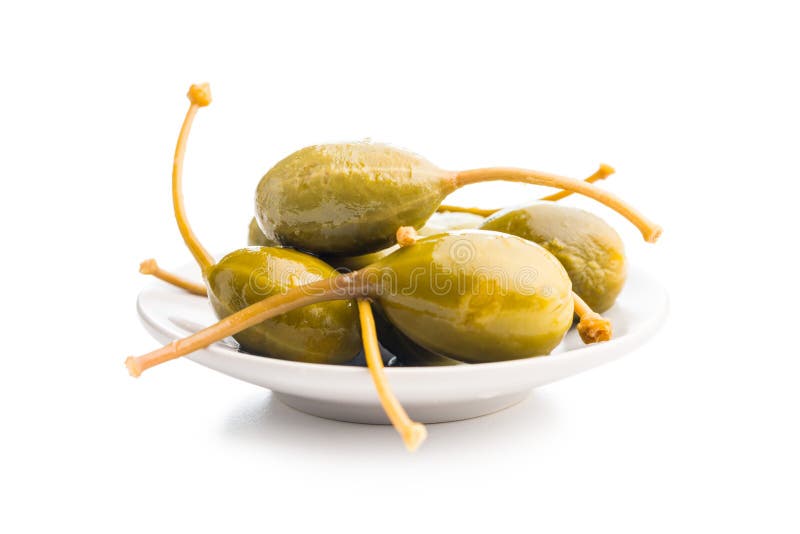 Pickled capers berries in bowl isolated on white background royalty free stock images