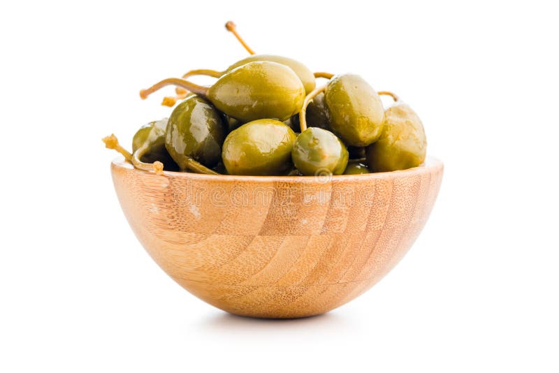 Pickled capers berries in bowl isolated on white background stock image