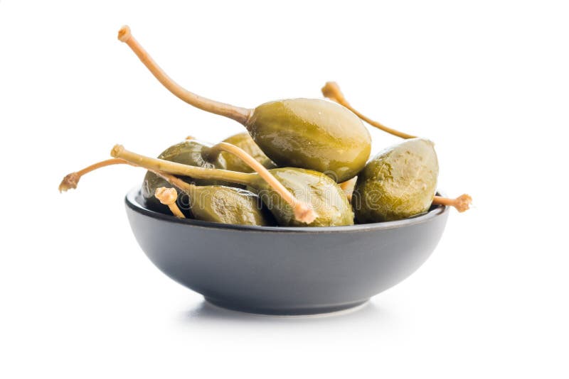 Pickled capers berries in bowl isolated on white background royalty free stock photos