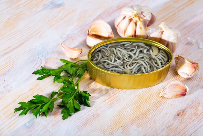 Pickled Eels in Open Tin Can with Garlic at Table Stock Photo Image