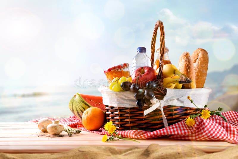 Picknick rieten mand met voedsel op lijst aangaande het strand stock fotografie Picknick rieten mand met voedsel op lijst aangaande het strand stock fotografie
