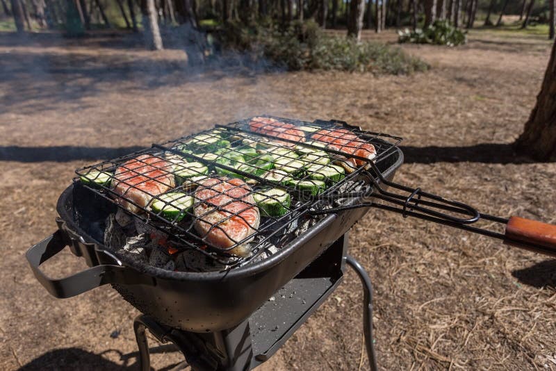 Picknickmatlagning utomhus med ett galler arkivbilder Picknickmatlagning utomhus med ett galler arkivbilder