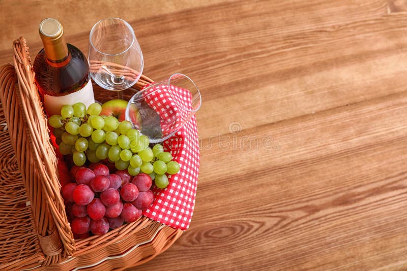 Picnic Basket with Wine, Glasses and Grapes on Wooden Table Stock Image