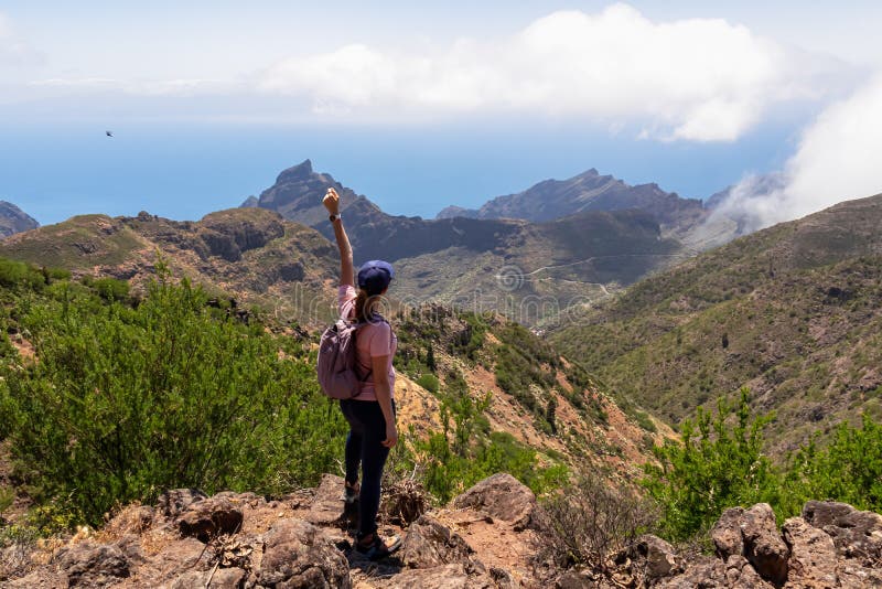 Pico verde-kvinna med ryggsäck som njuter av panoramisk syn på teno-bergsmassivet, sett från toppmötet pico verde tenerife. arkivbild