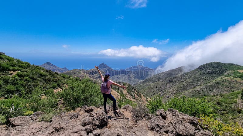 Pico verde-kvinna med ryggsäck som njuter av panoramisk syn på teno-bergsmassivet, sett från toppmötet pico verde tenerife. royaltyfri bild