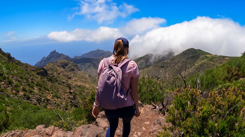 Pico verde-kvinna med ryggsäck som njuter av panoramisk syn på teno-bergsmassivet, sett från toppmötet pico verde tenerife. fotografering för bildbyråer
