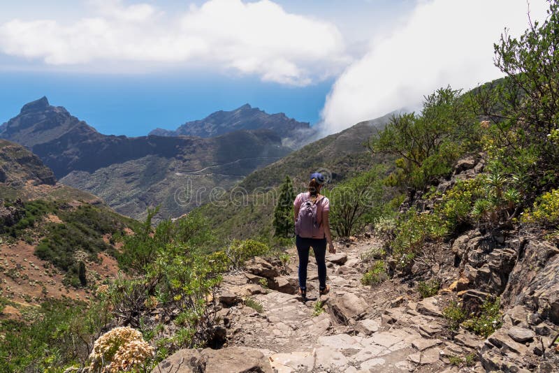 Pico verde-kvinna med ryggsäck som sjunker pikonverde med syn på teno-bergmassivtenerife. Höjd till masca royaltyfri foto