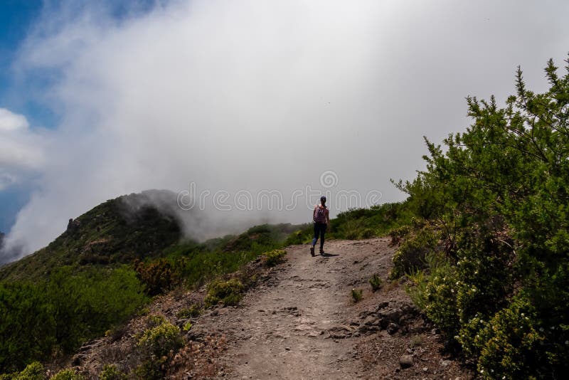 Pico verde-kvinna med ryggsäck som sjunker pikonverde med syn på teno-bergmassivtenerife. Höjd till masca royaltyfri fotografi