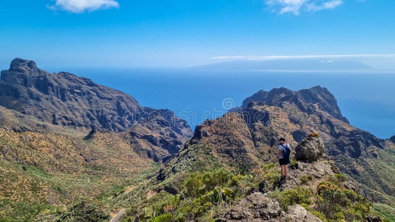 Pico verde man med ryggsäck med panoramisk syn på teno-bergsmassivet från toppmötet pico verde tenerife. arkivfoton
