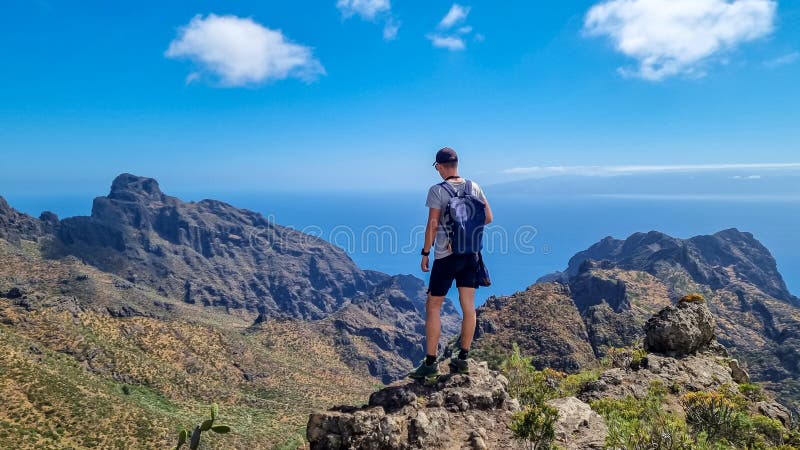 Pico verde man med ryggsäck med panoramisk syn på teno-bergsmassivet från toppmötet pico verde tenerife. royaltyfria foton