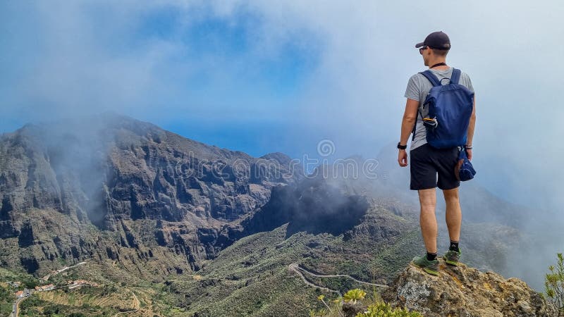 Pico verde man med ryggsäck som njuter av att se på teno-berget nära byns tenerife-kanariska öområde royaltyfri bild