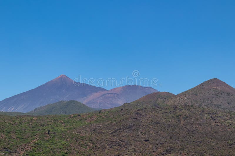 Pico verde scenvy över gröna kullar och toppmötet pico del teide som ses från byn Masca i bergsområdet teno. arkivbild