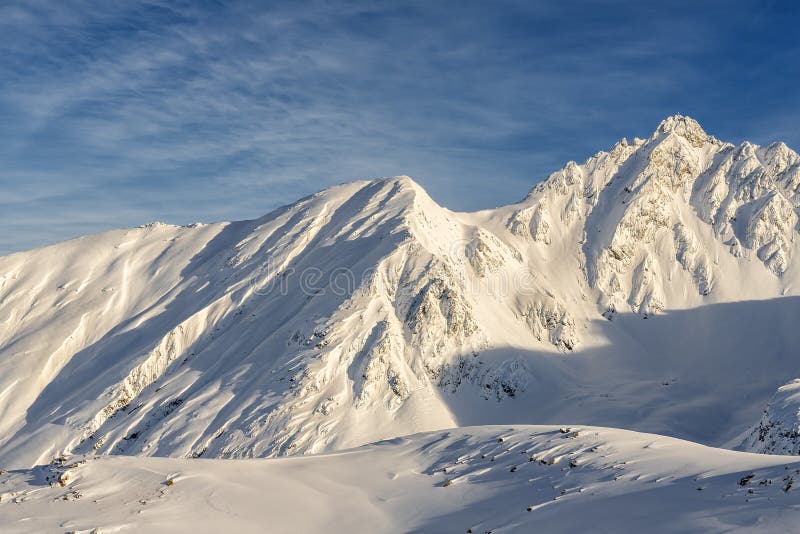 Picos cênicos da montanha alpina da Áustria cobertos com a camada de neve no inverno, ao pôr do sol quente ou ao nascer do sol Ch foto de stock Picos cênicos da montanha alpina da Áustria cobertos com a camada de neve no inverno, ao pôr do sol quente ou ao nascer do sol Ch foto de stock
