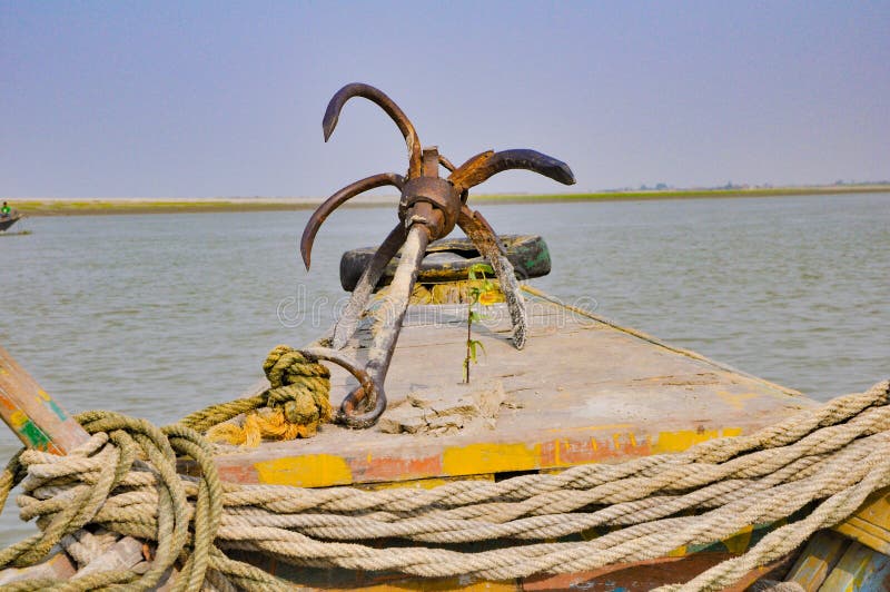 Picture of an anchor in the front of a boat in a river..with ropes and a tire.. royalty free stock images Picture of an anchor in the front of a boat in a river..with ropes and a tire.. royalty free stock images