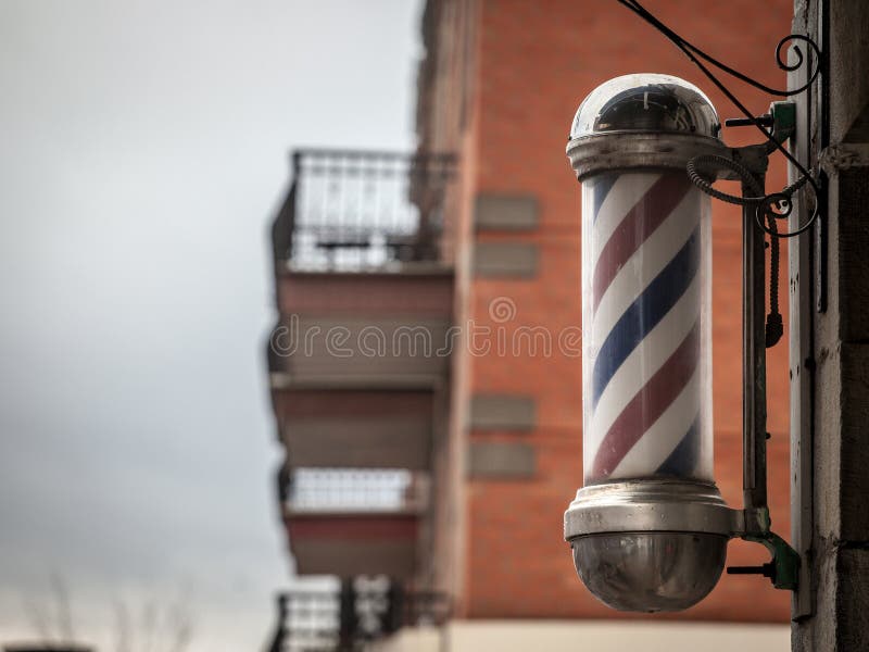 Typical American barbers pole seen in front of a barber shop of Montreal, Canada. stock photo Typical American barbers pole seen in front of a barber shop of Montreal, Canada. stock photo