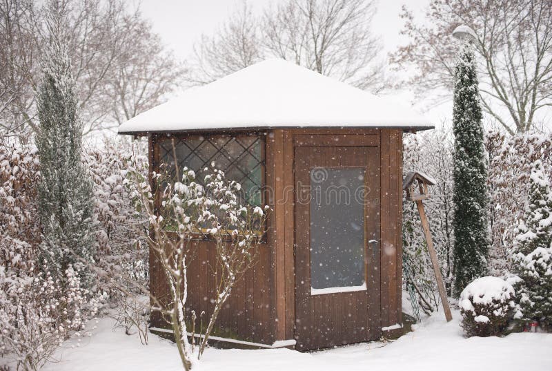 Picture of the garden and wooden garden house in the winter during a heavy snowing covered by snow. royalty free stock photo Picture of the garden and wooden garden house in the winter during a heavy snowing covered by snow. royalty free stock photo