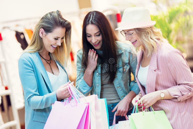 Picture of Group of Happy Friends Shopping for Clothes in Mall Stock ...