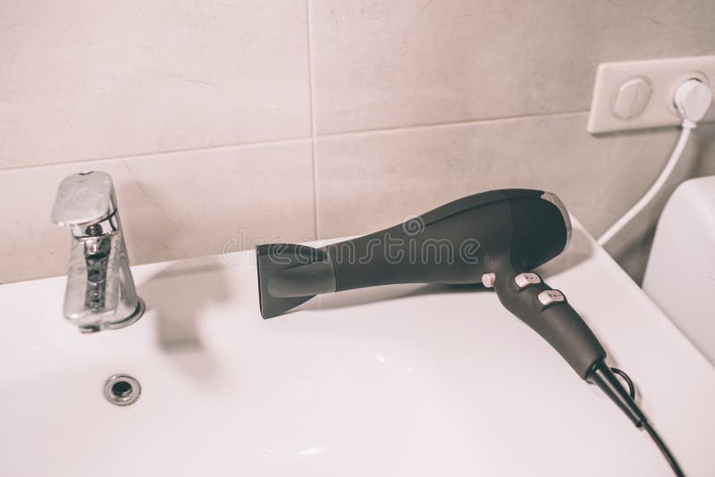Picture of Hair Dryer on Sink. it is Connected To Socket. Device is Lying  in Bathroom. Stock Image - Image of hairdryer, brunette: 126262623