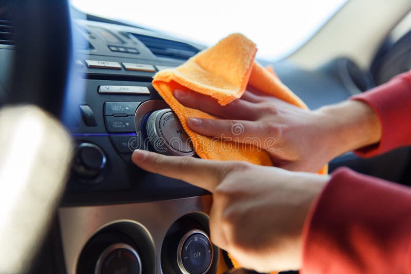 Picture of male`s hand with orange rag washing car interior, close-up