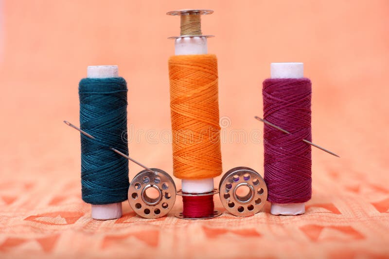 Picture of Sewing Thread and Bobbin with Needle on the Orange Cloth Stock Photo Image of