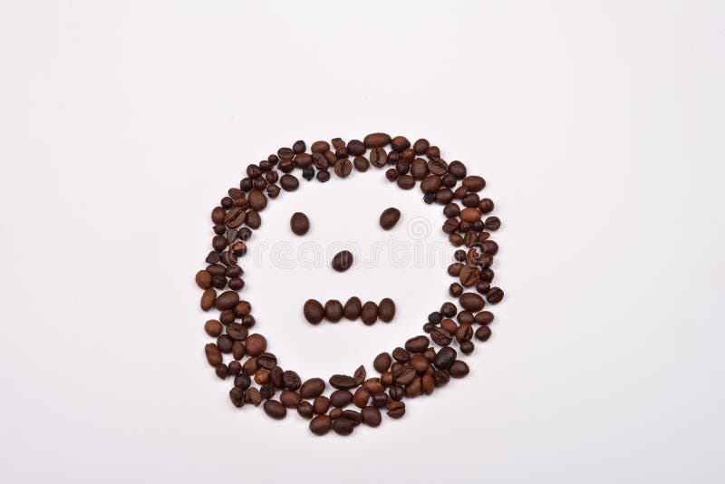 Picture shape face made of coffee beans on white background. Morning pleasure royalty free stock photography Picture shape face made of coffee beans on white background. Morning pleasure royalty free stock photography