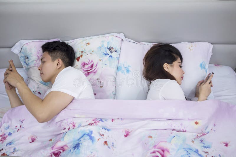 Couple lying back to back each other on the bed royalty free stock photography Couple lying back to back each other on the bed royalty free stock photography