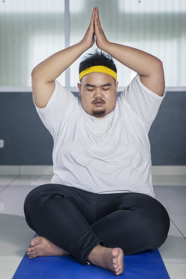 Relaxed fat man doing yoga Stock Photo by ©iakovenko123 119820450