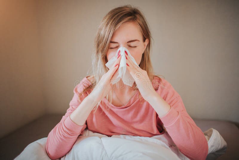 Picture from a young woman with handkerchief. Sick girl has runny nose. female model makes a cure for the common cold