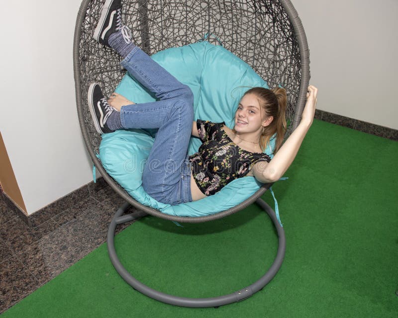 Hip thirteen year old girl relaxing in an egg chair royalty free stock image Hip thirteen year old girl relaxing in an egg chair royalty free stock image