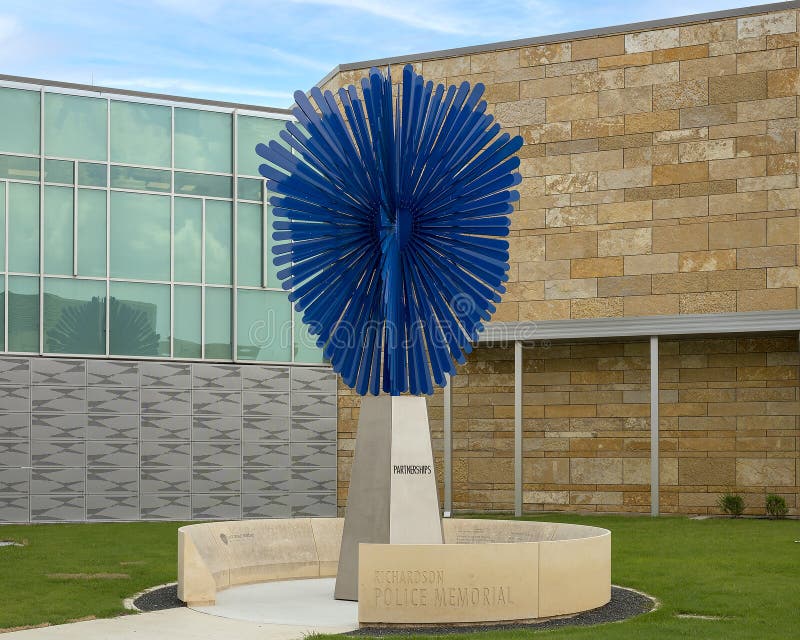 Pictured is a sculpture titled `Radiant Shield` by Shane Allbirtton and Norman Lee at the police station in the City of Richardson, Texas.  It is part of a police memorial, it`s surrounding low limestone wall being engraved on the inside with a quote, a poem, a reference to a fallen officer, and a dedication to the officers of the Richardson Police Department who have given their lives while serving and protecting the citizens.