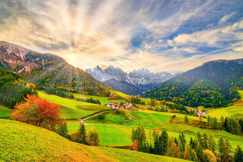 Picturesque autumn scenery in Santa Maddalena village with church, road, colorful trees and meadows on foreground and mountain peaks on background at sunrise. Dolomite Alps, South Tyrol, Italy fall sunbeam breathtaking stunning fine gorgeous lovely wonderful charming dolomiti popular magnificent grand majestic great known alto adige travel destination tourist attraction dramatic iconic unique fantastic postcard romantic tirol journey amazing trip high wonderland sunray seasonal autumnal. Picturesque autumn scenery in Santa Maddalena village with church, road, colorful trees and meadows on foreground and mountain peaks on background at sunrise. Dolomite Alps, South Tyrol, Italy fall sunbeam breathtaking stunning fine gorgeous lovely wonderful charming dolomiti popular magnificent grand majestic great known alto adige travel destination tourist attraction dramatic iconic unique fantastic postcard romantic tirol journey amazing trip high wonderland sunray seasonal autumnal