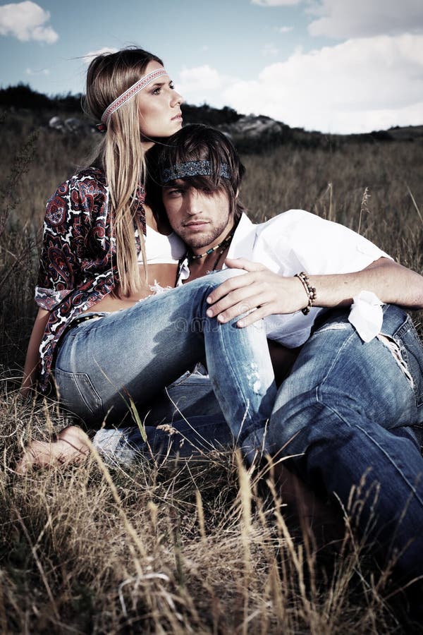 Beautiful young couple hippie posing together over picturesque landscape.