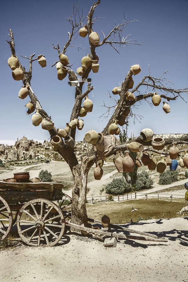 Picturesque landscape with jugs on a tree and old wagon full of clay pots, Cappadocia in Turkey.