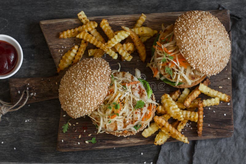 Piec na grillu kurczaka i coleslaw hamburgery na drewnianej desce zdjęcia royalty free Piec na grillu kurczaka i coleslaw hamburgery na drewnianej desce zdjęcia royalty free