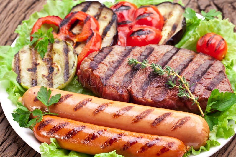Piec na grillu stek, kiełbasy i warzywa. zdjęcia royalty free Piec na grillu stek, kiełbasy i warzywa. zdjęcia royalty free