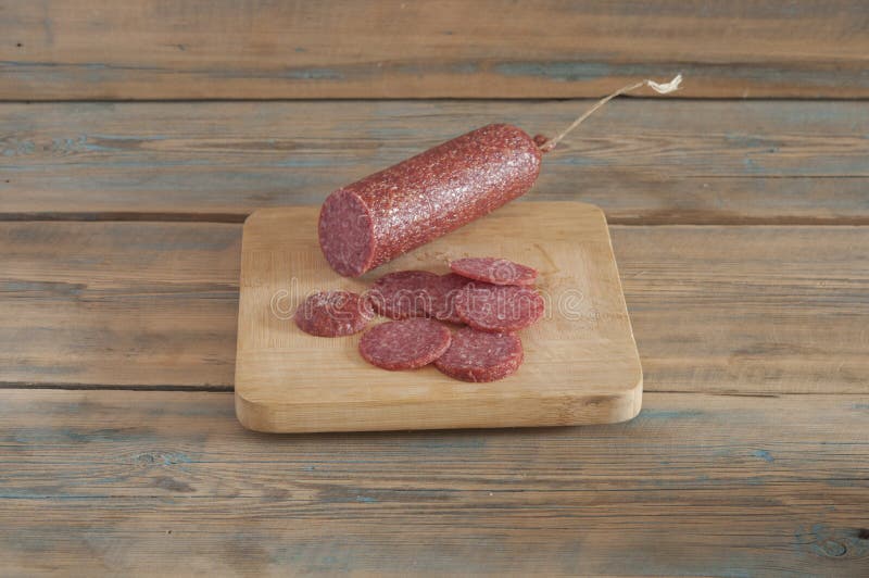 cheeses and sausage on wooden aged background.