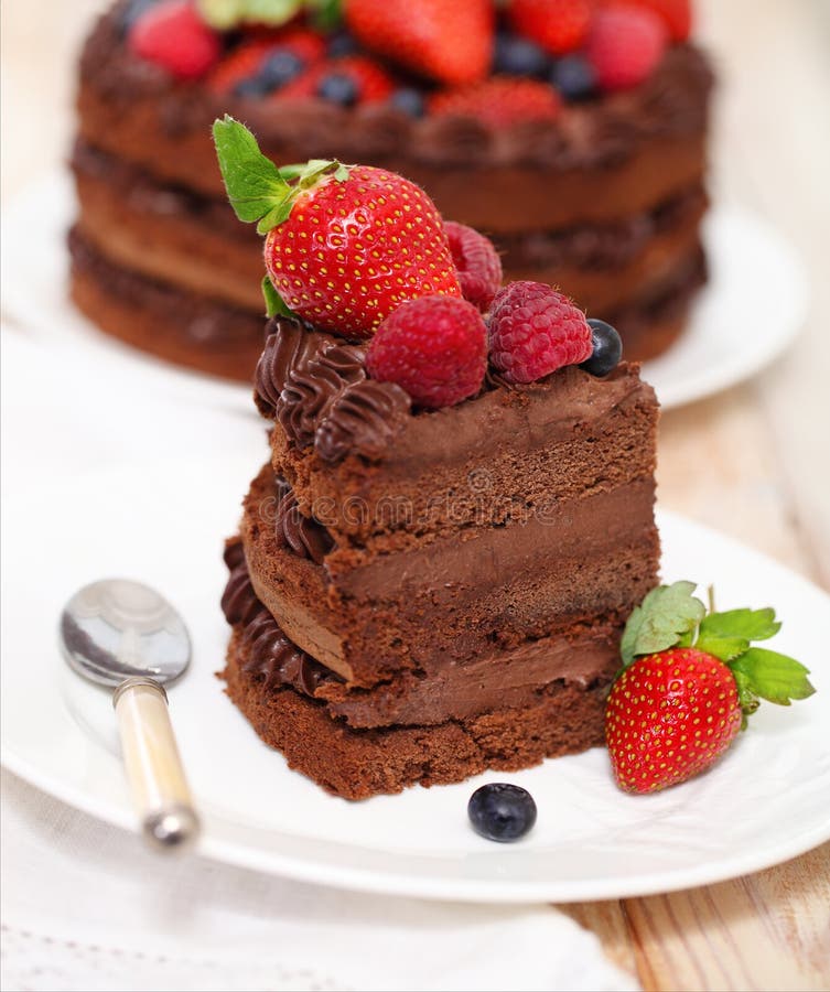 Piece of chocolate cake with icing and fresh berry