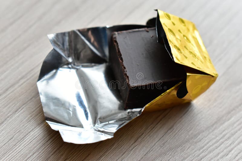 https://thumbs.dreamstime.com/b/piece-chocolate-gold-wrapper-gold-piece-chocolate-gold-wrapper-dark-background-delicious-food-sugar-illustration-170385753.jpg